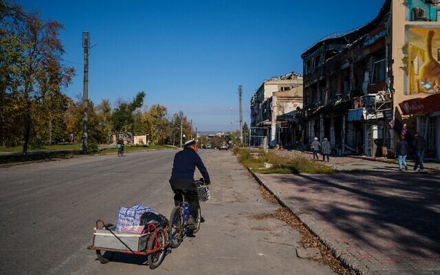 This photograph taken on October 18, 2022, shows a local resident riding a bicycle in the town of Izyum, amid Russian invasion of Ukraine. (Dimitar DILKOFF / AFP) This photograph taken on October 18, 2022, shows a local resident riding a bicycle in the town of Izyum, amid Russian invasion of Ukraine. (Dimitar DILKOFF / AFP)
