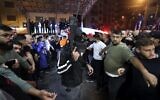 A member of the Lion's Den group escorts injured men into a hospital after clashes with Israeli forces in Nablus, in the West Bank on early October 25, 2022. (Jaafar Ashtiyeh/AFP)