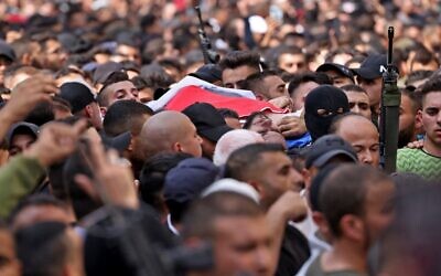 Mourners and gunmen carry the body of a member of the Lion's Den terror group, who was among six killed in an Israeli raid, during their funeral in the West Bank city of Nablus on October 25, 2022. (Ronaldo Schemidt/AFP)
