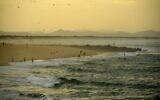 People walk along the beach in warm weather, in Capbreton, southwestern France, on October 27, 2022. (GAIZKA IROZ / AFP)