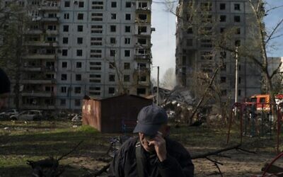 Mucola Markovich, 76, wipes a tear as he stands next to a residential building that was heavily damaged after a Russian attack at a residential area in Zaporizhzhia, Ukraine, October 9, 2022. (AP Photo/Leo Correa)