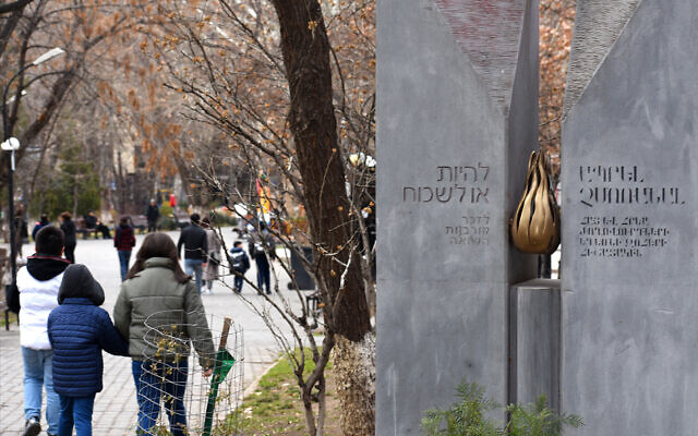 People walk past the Holocaust memorial in Yerevan, which is inscribed in Hebrew and Armenian: 'To be or to forget: Remember the victims of the Shoah.' (Larry Luxner)