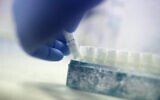 Illustrative -- In this May 15, 2018, photo, a scientist picks up a vial containing frozen donor sperm samples in a lab in Melbourne, Australia. (AP Photo/Wong Maye-E)