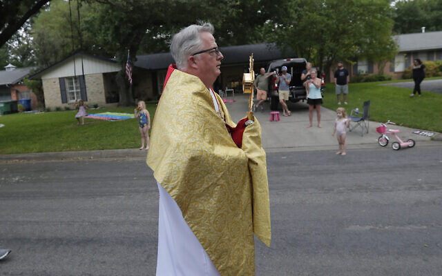 Using social distancing due to the COVID-19 pandemic, the Rev. Pat O'Brien, of St.Pius X Catholic Church, leads a Eucharistic procession through a neighborhood near his church in San Antonio, Monday, April 27, 2020. (AP/Eric Gay) Using social distancing due to the COVID-19 pandemic, the Rev. Pat O'Brien, of St.Pius X Catholic Church, leads a Eucharistic procession through a neighborhood near his church in San Antonio, Monday, April 27, 2020. (AP/Eric Gay)