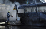 Illustrative: A Syrian firefighter extinguishes a burned bus at the site of a deadly explosion, in Damascus, Syria, October 20, 2021. (SANA via AP)
