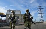 Russian troops guard an entrance of the Kakhovka Hydroelectric Station on the Dnieper River in Kherson region, south Ukraine, on May 20, 2022. (AP Photo, File)