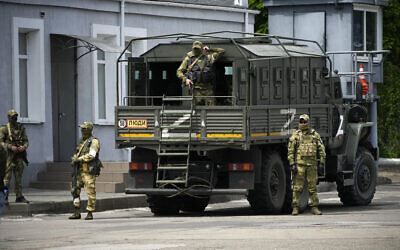 Russian soldiers guard an area as a group of foreign journalists visit in Kherson, Kherson region, south Ukraine, May 20, 2022. (AP Photo, File)