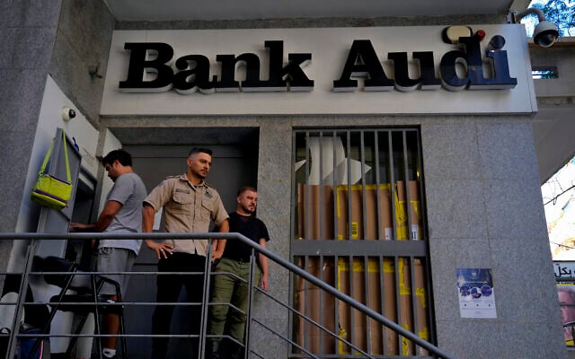 A man, left, uses an ATM to withdraw money, as security stand guard outside A Bank Audi branch, in Beirut, Lebanon, Monday, September 26, 2022. (AP/Bilal Hussein) A man, left, uses an ATM to withdraw money, as security stand guard outside A Bank Audi branch, in Beirut, Lebanon, Monday, September 26, 2022. (AP/Bilal Hussein)