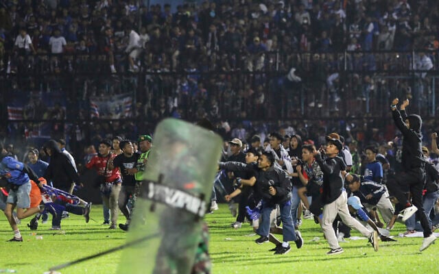 Soccer fans enter the pitch during a clash between supporters at Kanjuruhan Stadium in Malang, East Java, Indonesia, Saturday, Oct. 1, 2022. Panic following police actions left over 100 dead, mostly trampled to death, police said Sunday. (AP/Yudha Prabowo) Soccer fans enter the pitch during a clash between supporters at Kanjuruhan Stadium in Malang, East Java, Indonesia, Saturday, Oct. 1, 2022. Panic following police actions left over 100 dead, mostly trampled to death, police said Sunday. (AP/Yudha Prabowo)