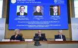 Royal Swedish Academy of Sciences secretary general Hans Ellegren, center announces the winner of the 2022 Nobel Prize in Physics, from left to right on the screen, Alain Aspect, John F. Clauser and Anton Zeilinger,  in Stockholm, Sweden, Oct. 4, 2022. (Jonas Ekstromer /TT News Agency via AP)