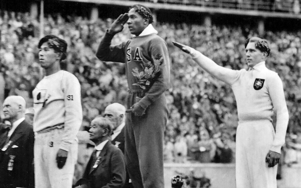 The United States' Jesse Owens, center, salutes during the presentation of his gold medal for the long jump, alongside German silver medalist Luz Long, who performs a Nazi salute, right, and bronze medalist Naoto Tajima, of Japan, during the eleventh Summer Olympics in Berlin, Germany, August 11, 1936. (AP Photo) The United States' Jesse Owens, center, salutes during the presentation of his gold medal for the long jump, alongside German silver medalist Luz Long, who performs a Nazi salute, right, and bronze medalist Naoto Tajima, of Japan, during the eleventh Summer Olympics in Berlin, Germany, August 11, 1936. (AP Photo)