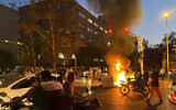 In this Monday, Sept. 19, 2022, photo taken by an individual not employed by the Associated Press and obtained by the AP outside Iran, a police motorcycle and a trash bin are burning during a protest over the death of Mahsa Amini, a 22-year-old woman who had been detained by the nation's morality police, in downtown Tehran, Iran.   (AP Photo)