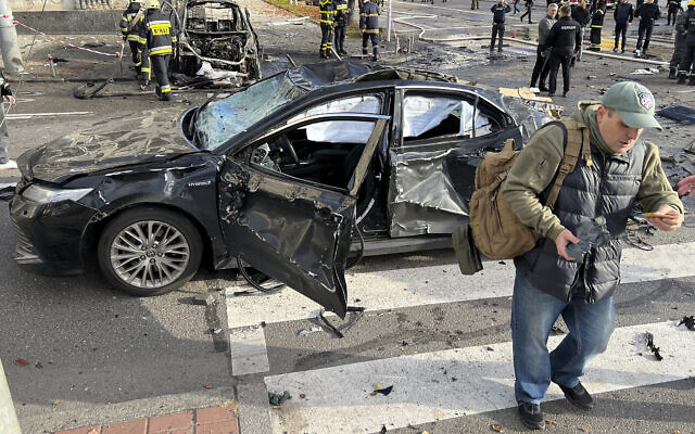 Rescue workers survey the scene of a Russian attack on Kyiv, Ukraine on October 10, 2022. (AP Photo/Adam Schreck)