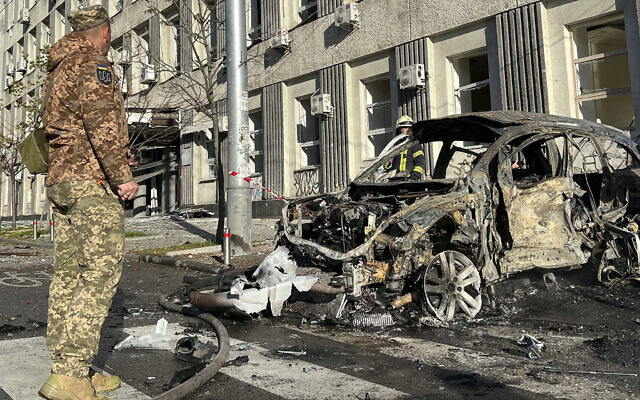 Rescue workers survey the scene of a Russian attack on Kyiv, Ukraine on October 10, 2022. (AP Photo/Adam Schreck)