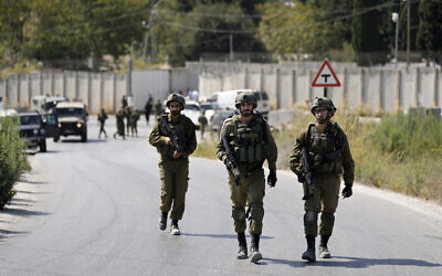 Israeli soldiers near the site where a soldier was killed by gunfire near the West Bank settlement of Shavei Shomron, Oct. 11, 2022. (AP Photo/Majdi Mohammed, file)