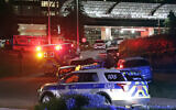 An EMS vehicle believed to be carrying the suspect in a multiple shooting arrives at WakeMed emergency room with a heavy police escort in Raleigh, North Carolina, Oct. 13, 2022. (AP Photo/Chris Seward)