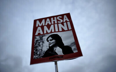 A woman holds a placard with a picture of Iranian woman Mahsa Amini during a protest against her death, in Berlin, Germany, September 28, 2022. (Markus Schreiber/AP)