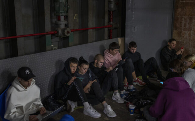 People sit in the Kyiv subway, using it as a bomb shelter, in Kyiv, Ukraine, on Wednesday, Oct. 19, 2022. (AP Photo/Emilio Morenatti)