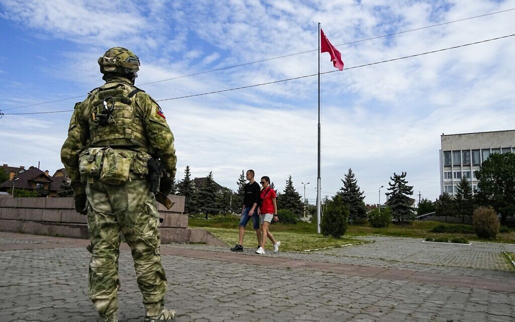 A young couple walks past a Russian soldier guarding an area at the Alley of Glory during the occupation of Kherson, in south Ukraine, May 20, 2022. (AP Photo, File) A young couple walks past a Russian soldier guarding an area at the Alley of Glory during the occupation of Kherson, in south Ukraine, May 20, 2022. (AP Photo, File)