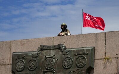 A Russian soldier guards an area at the Alley of Glory exploits of the heroes - natives of the Kherson region, who took part in the liberation of the region from the Nazi invaders, in Kherson, Kherson region, south Ukraine, on May 20, 2022. (AP Photo, File)
