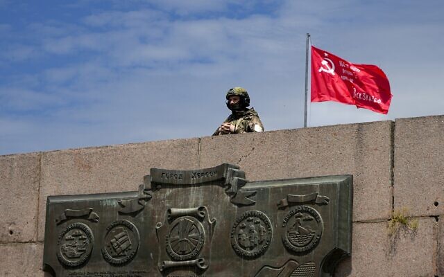 A Russian soldier guards an area at the Alley of Glory exploits of the heroes - natives of the Kherson region, who took part in the liberation of the region from the Nazi invaders, in Kherson, Kherson region, south Ukraine, on May 20, 2022. (AP Photo, File)