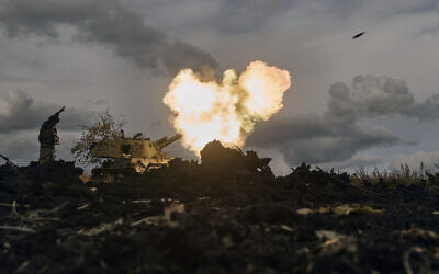 A Ukrainian serviceman reacts as a self-propelled artillery vehicle fires near Bakhmut, Donetsk region, Ukraine, October 22, 2022. (AP Photo/LIBKOS)