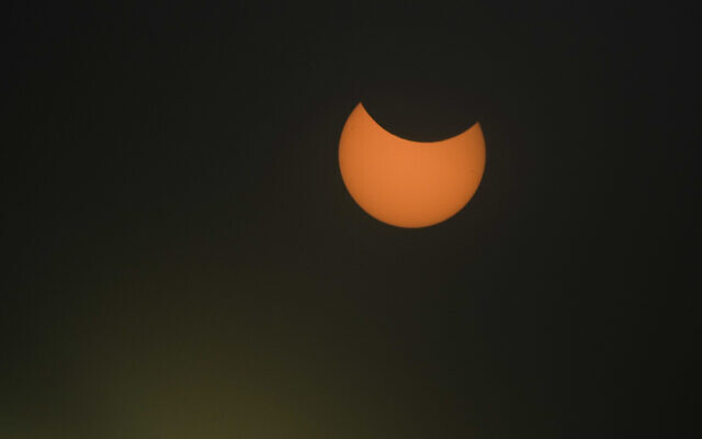 Through a filter this partial solar eclipse, the moon covers a part of the sun in the town of Givatayim, near Tel Aviv, October 25, 2022. (AP Photo/Ariel Schalit) Through a filter this partial solar eclipse, the moon covers a part of the sun in the town of Givatayim, near Tel Aviv, October 25, 2022. (AP Photo/Ariel Schalit)