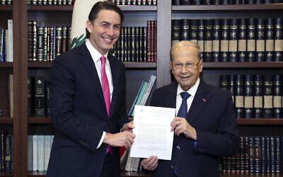Lebanese President Michel Aoun, right, receives from US Envoy for Energy Affairs Amos Hochstein, the US-brokered deal setting a maritime border between Lebanon and Israel, at the presidential palace, in Beirut, Lebanon, October 27, 2022.  (Dalati Nohra via AP)