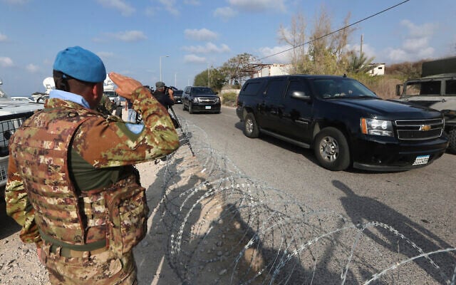 A UN peacekeeper soldier, left, salutes the convoy of the Lebanese delegation as it drives towards a UN post along the border where Lebanese and Israeli delegations were to meet to sign a maritime border deal on Thursday, Oct. 27, 2022. (AP Photo/Mohammed Zaatari)