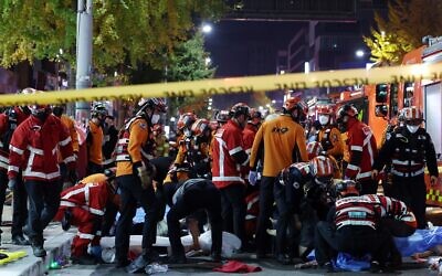 Rescue workers and firefighters work on the scene of a crushing accident in Seoul, South Korea, Saturday, October 29, 2022. (Lee Ji-eun/Yonhap via AP)