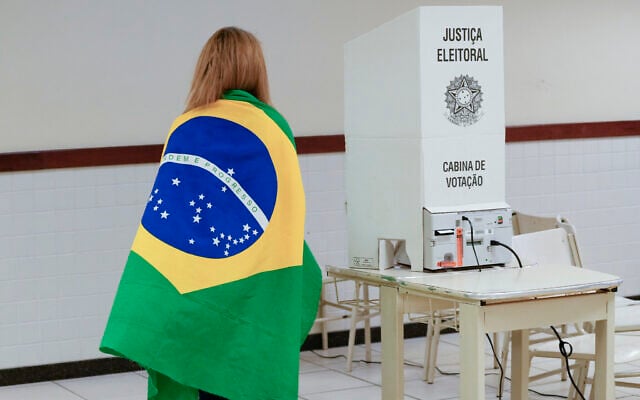 A voter wrapped in a Brazilian flag arrives to vote in a presidential a run-off pitting President Jair Bolsonaro against former president Luiz Inácio Lula da Silva, in Brasilia, Brazil, Oct. 30, 2022. (AP Photo/Eraldo Peres) A voter wrapped in a Brazilian flag arrives to vote in a presidential a run-off pitting President Jair Bolsonaro against former president Luiz Inácio Lula da Silva, in Brasilia, Brazil, Oct. 30, 2022. (AP Photo/Eraldo Peres)