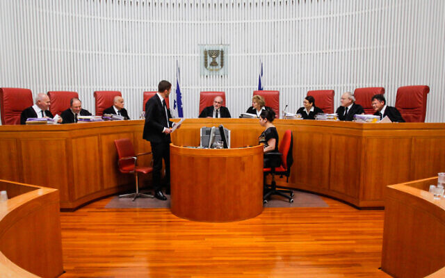 A nine-judge panel of the High Court of Justice headed by then-Supreme Court President Asher Grunis during a hearing of a petition by human rights groups against the an amendment to the Prevention of Infiltration Law, April 1, 2014. (Flash90) A nine-judge panel of the High Court of Justice headed by then-Supreme Court President Asher Grunis during a hearing of a petition by human rights groups against the an amendment to the Prevention of Infiltration Law, April 1, 2014. (Flash90)