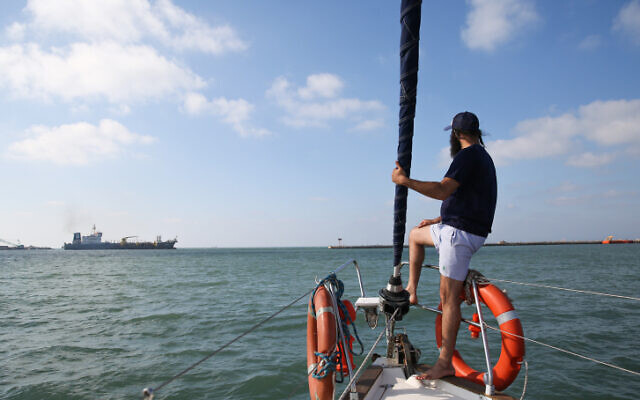 Illustrative: A man looks out to the sea from a boat off Haifa's Kishon Port on June 26, 2018. (David Cohen/Flash90)