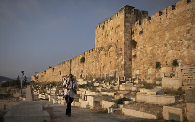 Illustrative: An Orthodox Jewish man walks past the Golden Gate, as he circles around all the gates to the Temple Mount while praying in Jerusalem's Old City, early morning on August 4, 2019. (Hadas Parush/Flash90)