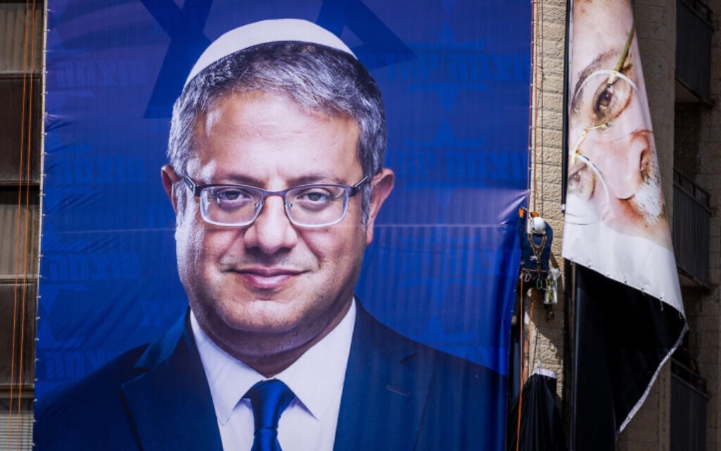 Workers hang a large election campaign poster of Otzma Yehudit head Itamar Ben Gvir and take down a poster of Arab MK Ahmad Tibi, in Jerusalem on September 29, 2022. (Yonatan Sindel/Flash90) Workers hang a large election campaign poster of Otzma Yehudit head Itamar Ben Gvir and take down a poster of Arab MK Ahmad Tibi, in Jerusalem on September 29, 2022. (Yonatan Sindel/Flash90)