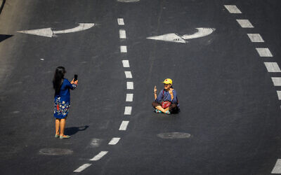 People walk on the empty road at the entrance to Jerusalem, on Yom Kippur, the Day of Atonement, October 5, 2022. (Jamal Awad/Flash90)