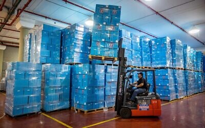 Workers prepare ballot boxes for the upcoming Israeli elections, at the Central Elections Committee warehouse in Shoham, before they are shipped to polling stations, October 12, 2022. (Yonatan Sindel/Flash90)