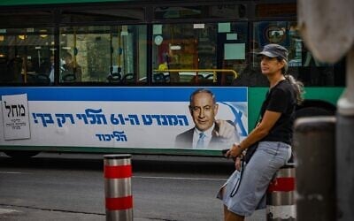 A bus with a campaign poster for opposition leader Benjamin Netanyahu's Likud party passes by the Mahane Yehuda market in Jerusalem on October 30, 2022. The poster says: "The 61st seat depends only on you!" (Olivier Ftoussi/Flash90)