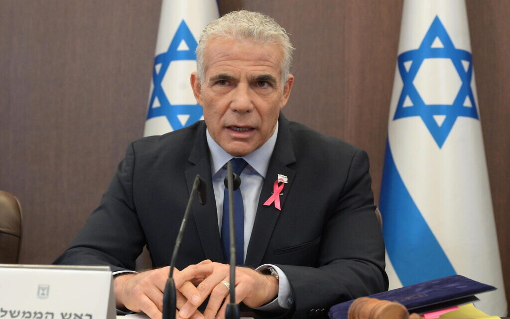 Prime Minister Yair Lapid, wearing a pink ribbon for breast cancer awareness, leads the weekly cabinet meeting at the Prime Minister's Office in Jerusalem, October 2, 2022. (Amos Ben Gershon/GPO)