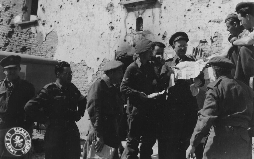 The rabbi of the Jewish Brigade visits an aid station in Italy and distributes newspapers, March 1945. (Photographer: Levine, 196th Signal Photo Co./Signal Corps Archive from United States, Public domain, via Wikimedia Commons)