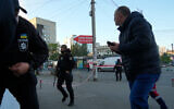 People react as a drone fires on buildings in Kyiv, Ukraine, Oct. 17, 2022. (AP Photo/Efrem Lukatsky)