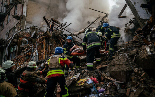 Ukrainian firefighters carry the body of a civilian killed in Russian a strike in Zaporizhzhia, Ukraine, October 6, 2022.
(Dimitar Dilkoff/AFP)