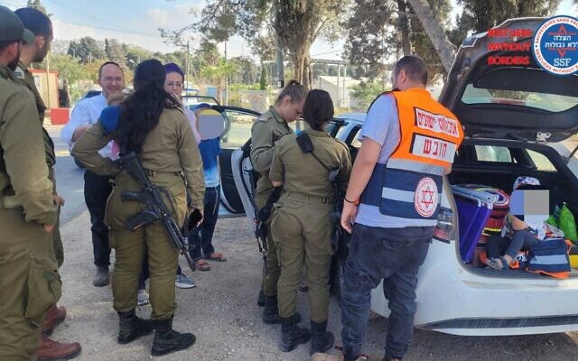 Medics and soldiers treat a young Israeli boy who was hurt in a stone-throwing attack near Huwara in the West Bank, October 13, 2022. (Rescuers Without Borders) Medics and soldiers treat a young Israeli boy who was hurt in a stone-throwing attack near Huwara in the West Bank, October 13, 2022. (Rescuers Without Borders)