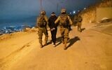 A handout photo released by the military on October 7, 2022, shows Israeli forces arresting Palestinian terror suspect Amad Asleem, a resident of the northern West Bank city of Nablus. (Israel Defense Forces)