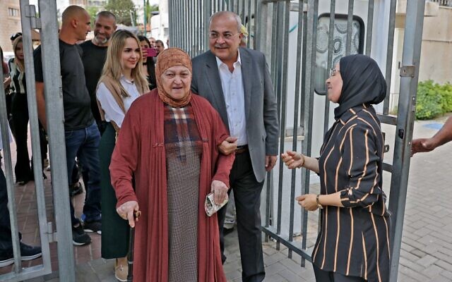 Ahmad Tibi (C-R behind), head of the Arab Movement for Change (Ta'al) party, walks with his mother (C) after voting at a polling station in the predominantly-Arab city of Taybeh in central Israel during the national elections on November 1, 2022. (Photo by AHMAD GHARABLI / AFP) Ahmad Tibi (C-R behind), head of the Arab Movement for Change (Ta'al) party, walks with his mother (C) after voting at a polling station in the predominantly-Arab city of Taybeh in central Israel during the national elections on November 1, 2022. (Photo by AHMAD GHARABLI / AFP)