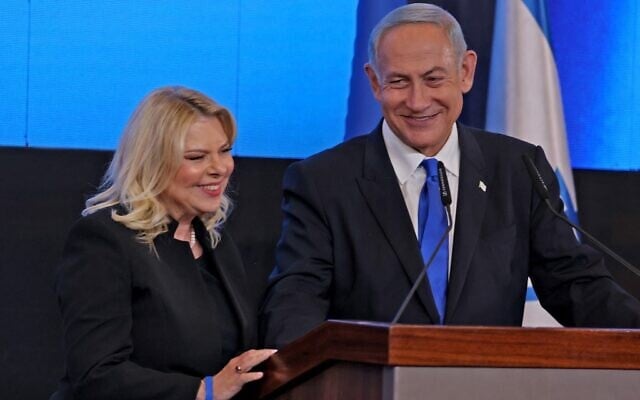 Leader of the Likud party Benjamin Netanyahu addresses supporters, flanked by his wife Sara, at campaign headquarters in Jerusalem early on November 2, 2022, after the end of voting for national elections (Menahem Kahana / AFP) Leader of the Likud party Benjamin Netanyahu addresses supporters, flanked by his wife Sara, at campaign headquarters in Jerusalem early on November 2, 2022, after the end of voting for national elections (Menahem Kahana / AFP)