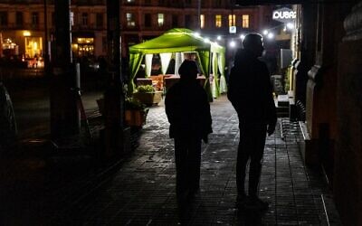 Pedestrians walk down a street during a power cut in downtown Kyiv on November 10, 2022, amid the Russian invasion of Ukraine. (Dimitar Dilkoff/AFP)