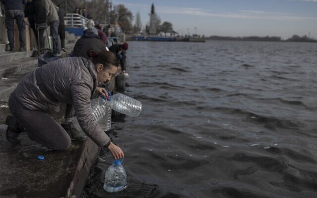 A woman takes water from the Dnipro River to use it for cleaning, in Kherson, November 14, 2022, amid Russia's invasion of Ukraine. (Photo by BULENT KILIC / AFP) A woman takes water from the Dnipro River to use it for cleaning, in Kherson, November 14, 2022, amid Russia's invasion of Ukraine. (Photo by BULENT KILIC / AFP)