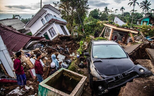 Villagers salvage items from damaged houses following a 5.6-magnitude earthquake that killed at least 268 people, with many hundreds injured and others missing in Cianjur on November 22, 2022. (Photo by ADITYA AJI / AFP)