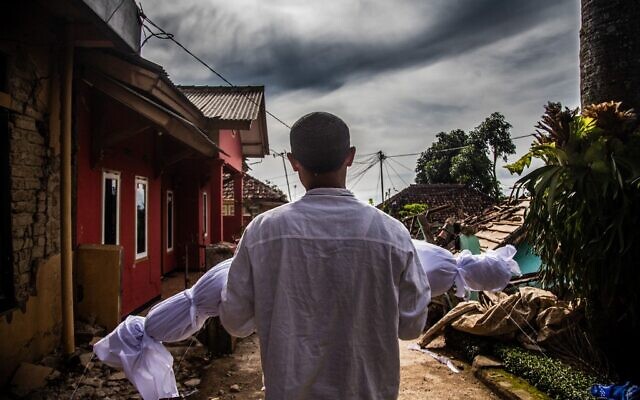 A villager carries the body of his dead son following a 5.6-magnitude earthquake that killed at least 268 people, with many hundreds injured and others missing in Cianjur on November 22, 2022. (Photo by ADITYA AJI / AFP)